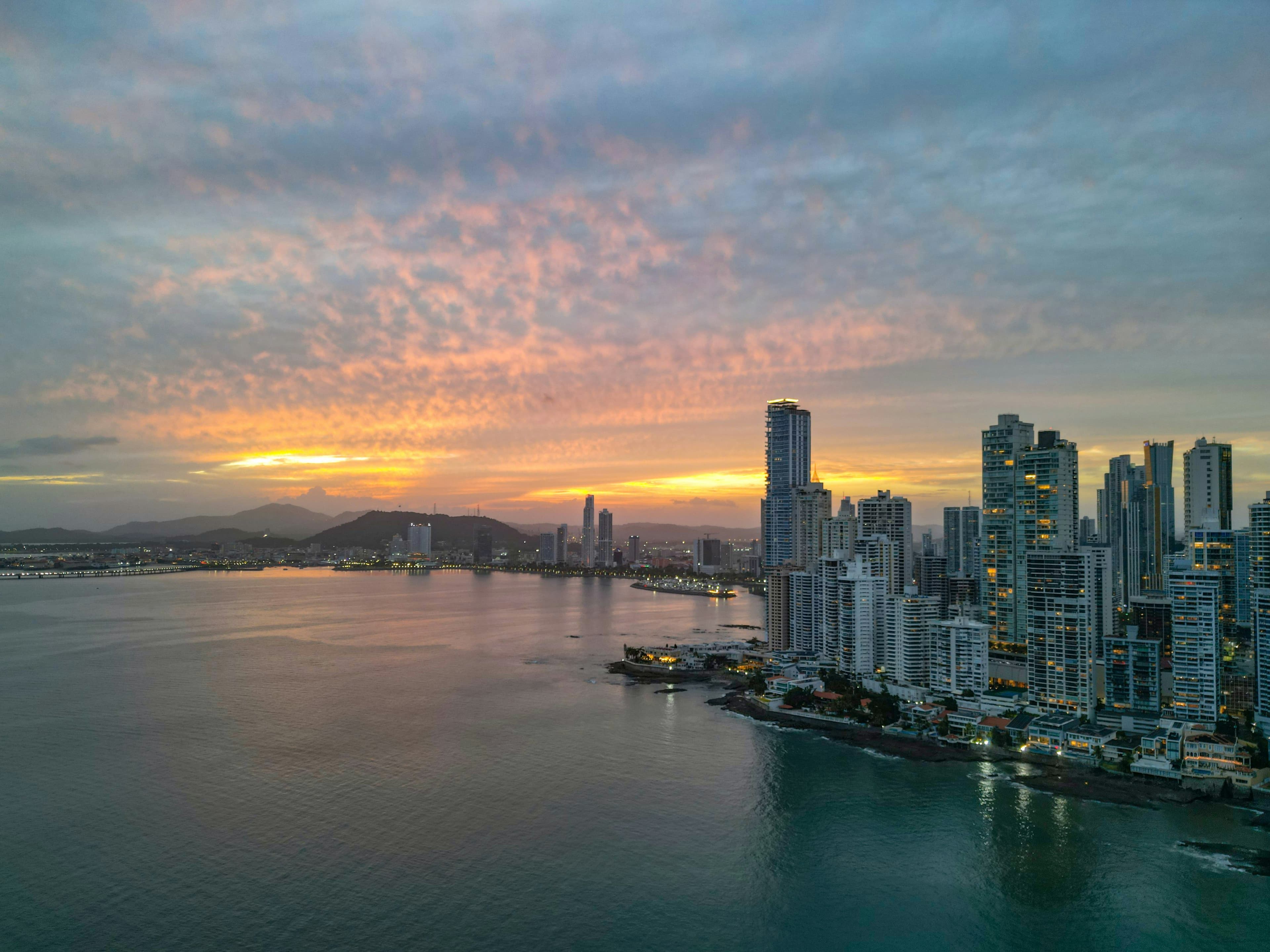 Perfil urbano de Ciudad de Panamá al atardecer, con el océano en primer plano