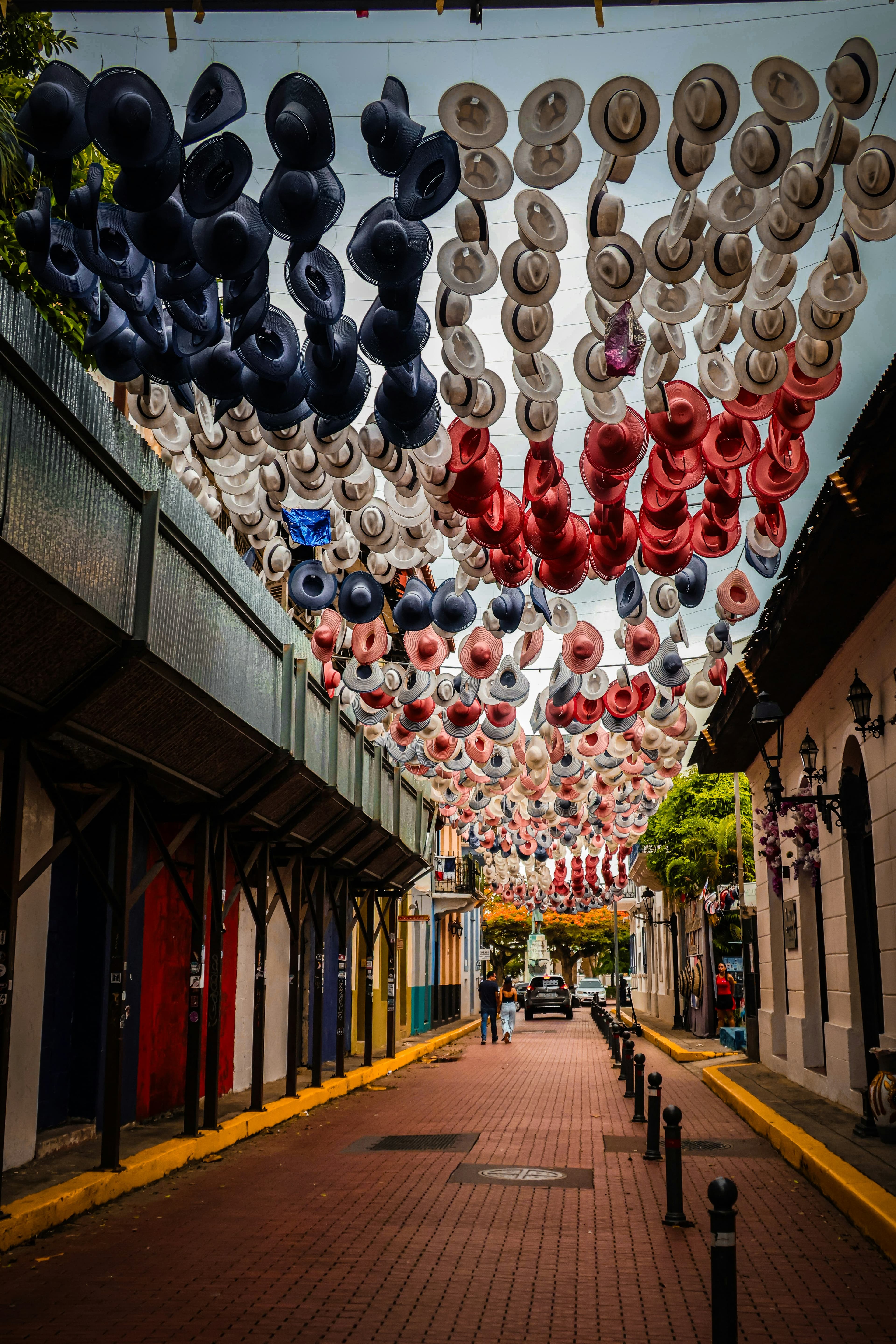 Calle del Casco Antiguo de Ciudad de Panamá decorada con sombreros de colores suspendidos sobre la vía