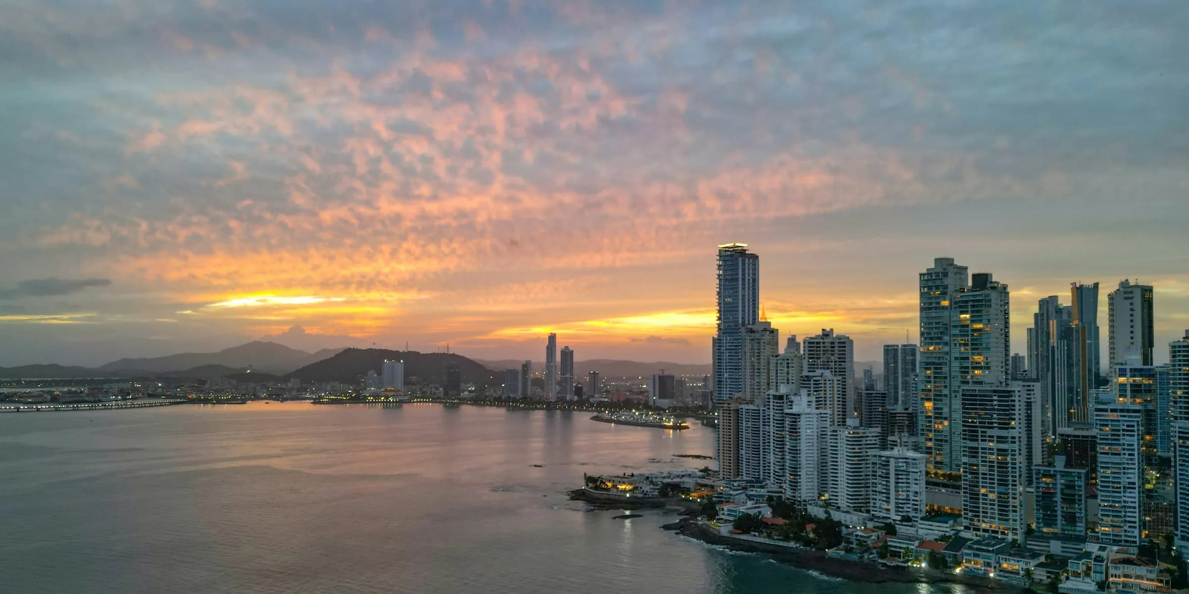 Atardecer sobre la bahía de Ciudad de Panamá, con las torres de Punta Paitilla a la derecha y el Cerro Ancón al fondo